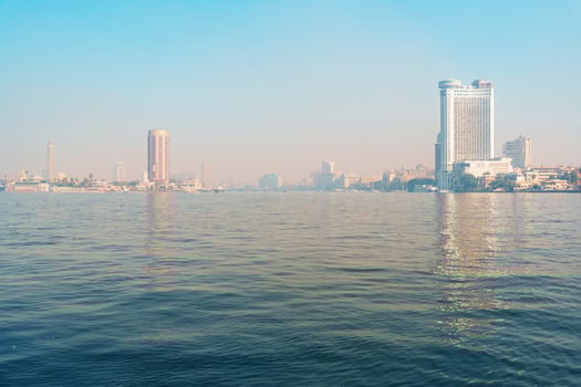Majestic view of Cairo skyline over the Nile River on a clear morning showcasing urban architecture and tranquil waters photo