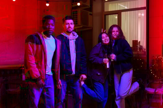 Group of friends enjoying a night out at a colorful venue with vibrant lighting in the background photo