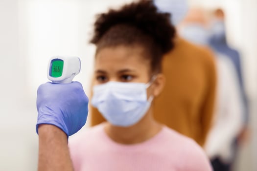 Medical Worker Doing Temperature Screening For Teen Girl And People Standing In Queue, Measuring Fever Using Contactless Themometer Indoors. Covid-19 Pandemic, Coronavirus Protection. Shallow Depth photo
