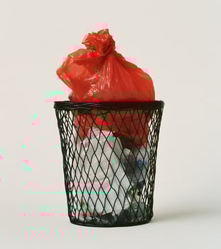 Red plastic garbage bag inside a black metal trash can. photo