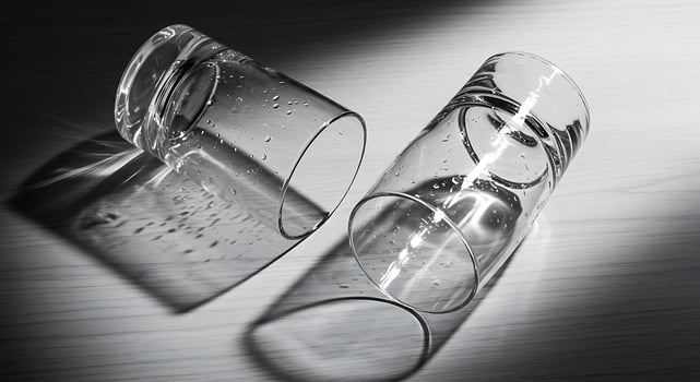 Two Empty Glasses Laying on Wooden Surface with Water Droplets photo