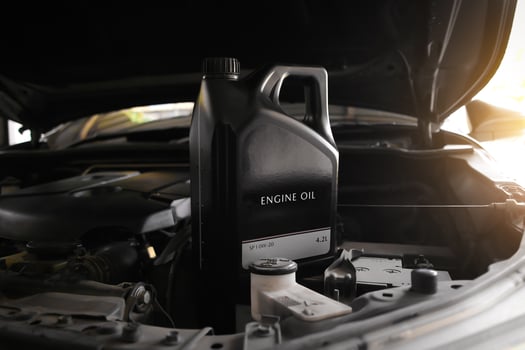 Engine Oil or Motor Oil, A black container sits in the open engine bay of a car, ready for an oil change. photo
