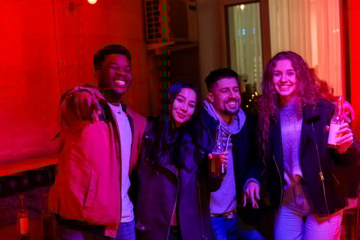 Friends enjoying a vibrant night out in a lively venue with colorful lighting in a city setting photo