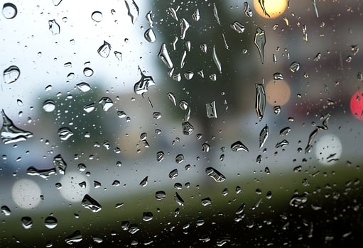 A view of a car driving down the road with rain drops on the window photo