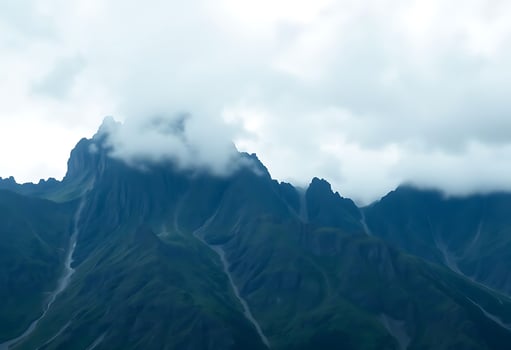 very tall mountain with some clouds in the sky photo