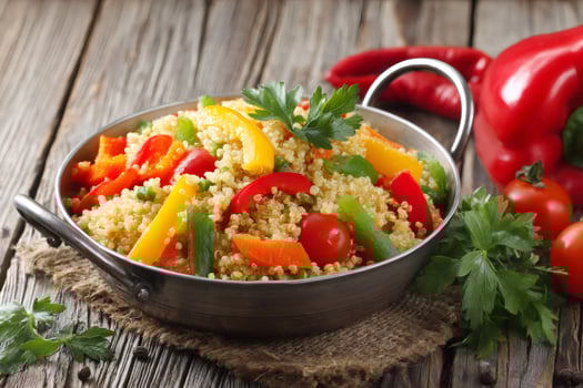 Quinoa salad with roasted vegetables in a pan on rustic wooden table photo