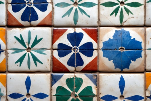 Colorful vintage ceramic tiles forming a floral pattern are decorating a wall photo