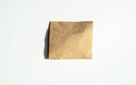 Square kraft sticker, sheet of brown note paper, isolated on a white background photo