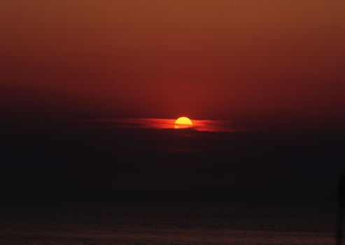 the sun setting over the ocean photo