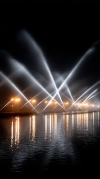 A large fountain of water is lit up at night photo
