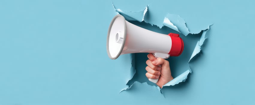 The megaphone breaking through a vibrant blue wall for impactful communication. photo