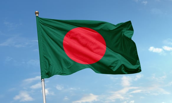 Bangladesh national flag with red circle on green background symbolizing the country's bloodshed for independence and lush landscape photo