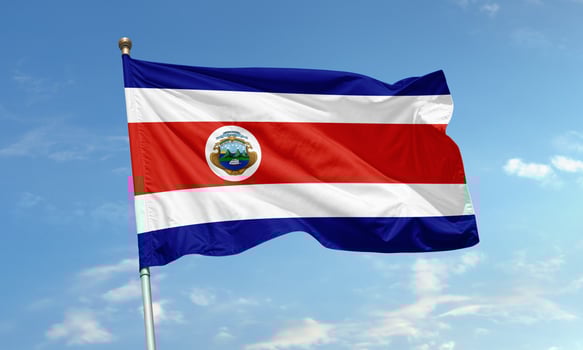 Costa Rican national flag with emblem waving in wind photo