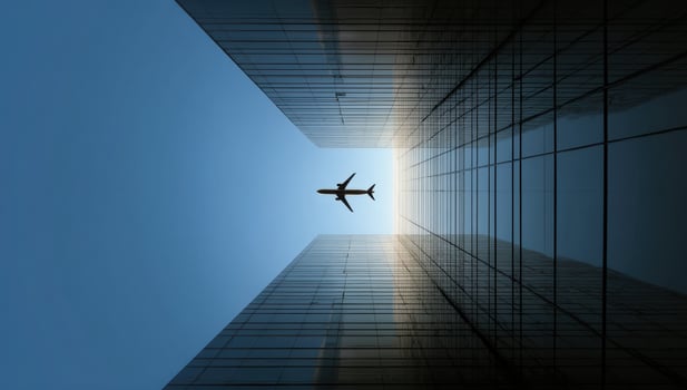 Looking Up at Airplane Flying Over Skyscrapers Reaching Towards the Sky photo