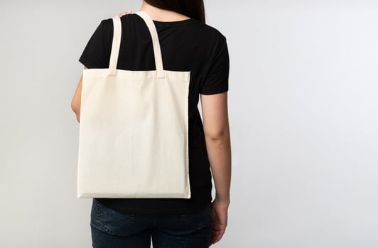 Say No To Plastic. Unrecognizable Brunette Girl Holding Eco Bag On White Studio Background. Back View, Cropped, Free Space photo