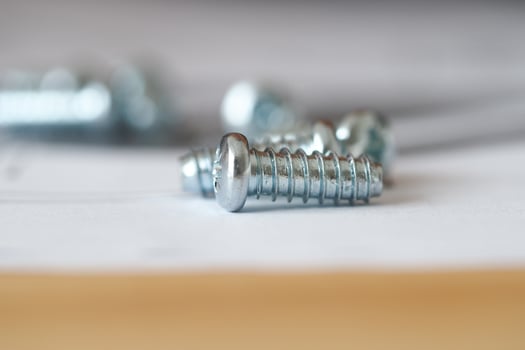 Close up of shiny screws on a work surface during assembly photo