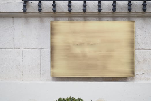 Wall mounted blank sign on white plaster surface photo