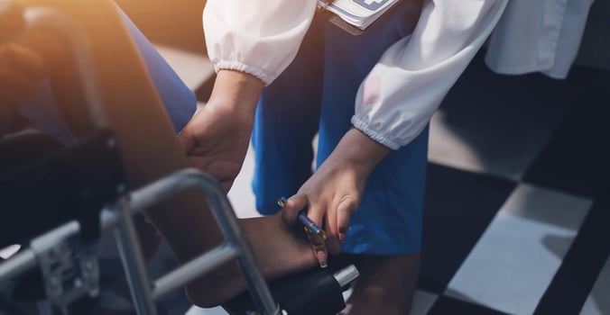 A doctor is putting on a patient's shoe photo