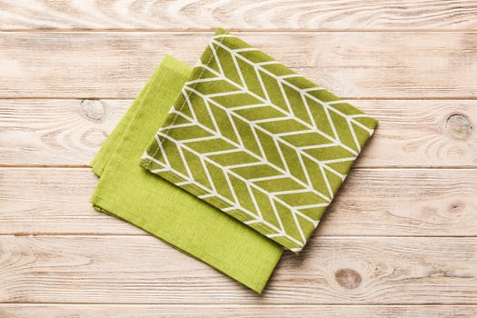 top view with green kitchen napkin isolated on table background. Folded cloth for mockup with copy space,Minimal style photo