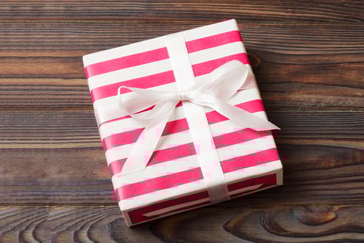 wrapped Christmas or other holiday handmade gift box in color paper with ribbon on colored background. Present box, decoration of gift photo