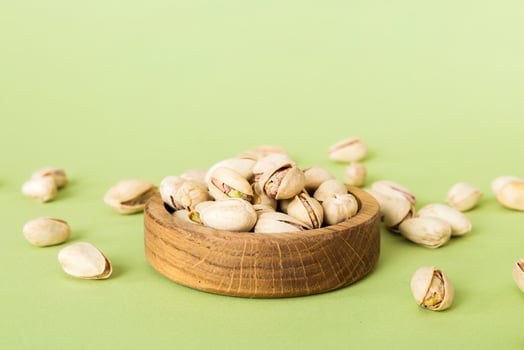 Fresh healthy Pistachios bowl on colored table background. Top view Healthy eating photo