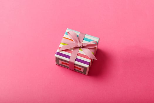 wrapped Christmas other holiday handmade gift box in color paper with ribbon on colored background. Present box, decoration gift on colored , top view photo