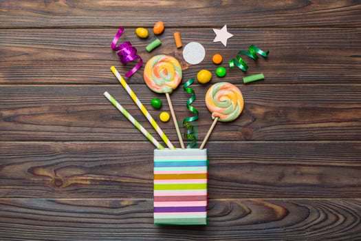 gift box corner full assorted traditional candies falling out on colored background with copy space. Happy Holidays photo