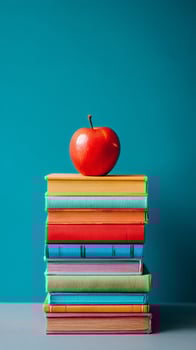Stacked Colorful Books With a Red Apple Placed on Top for a Creative Learning Concept. photo