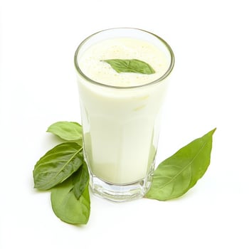 A glass of milk with basil leaves on top photo