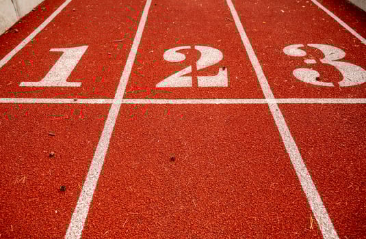 Red running track in stadium, with numbers at the start one, two, three, the running track is deep red. Sport recreation. Helthy lifestyle concept. High quality photo