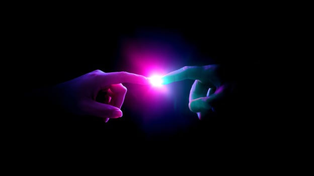 Light touches create a connection between two hands in a darkened space during a dramatic moment of interaction photo