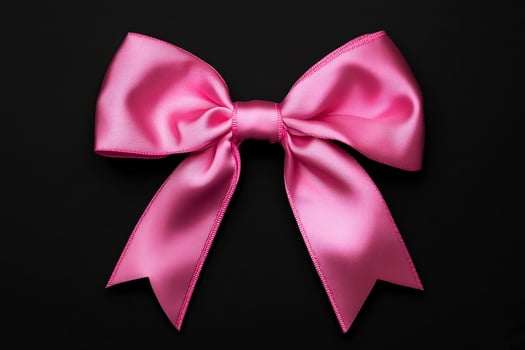 Pink satin bow with elegant loops and tails, beautifully arranged on a dark background, showcasing its smooth texture and vibrant color for decorative purposes photo