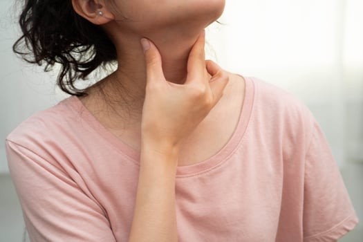 woman touching her neck and throat for thyroid photo
