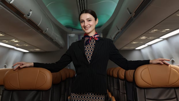 friendly flight attendant stand confidently inside an airplane cabin. photo