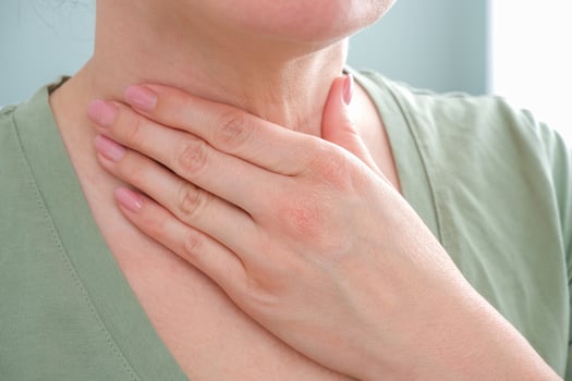 A woman has a sore throat, a man holds his hand to his neck photo