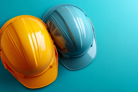 Yellow and blue hard hats representing workplace safety on turquoise background photo