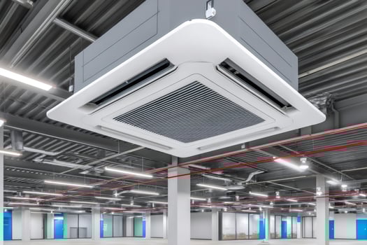Modern air conditioner hanging from ceiling in empty office space photo