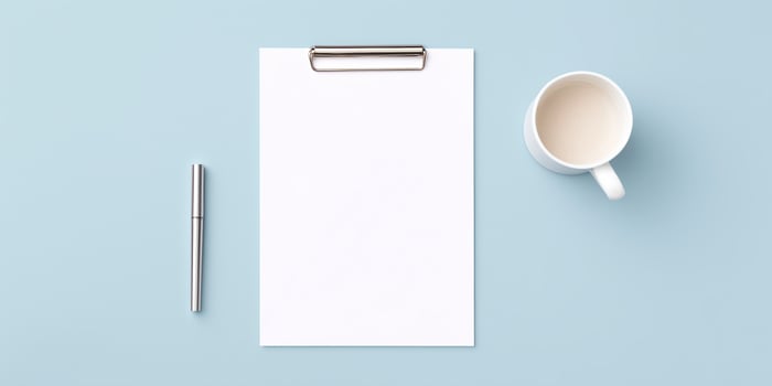 Blank clipboard with white sheet of paper, silver pen, and white coffee mug on a light blue background creating a minimalistic workspace atmosphere photo