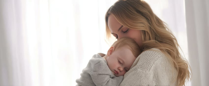 The loving embrace of a mother and her sleeping baby in a cozy environment. photo