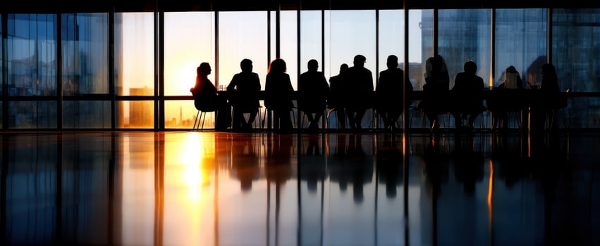 The silhouettes of professionals meeting against a stunning sunset backdrop. photo