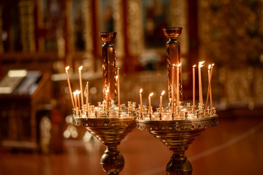 Close-up of two burning candles in a church interior, creating a warm and peaceful glow in a quiet, spiritual setting photo
