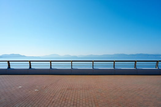 Beach Background Serene Seascape Brick Pathway Ocean View Metal Railing Calm Blue Sky photo