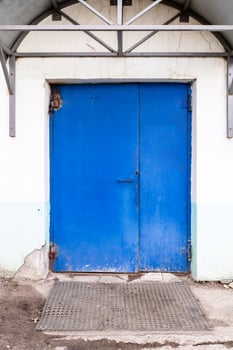 closed blue painted steel double door in building photo