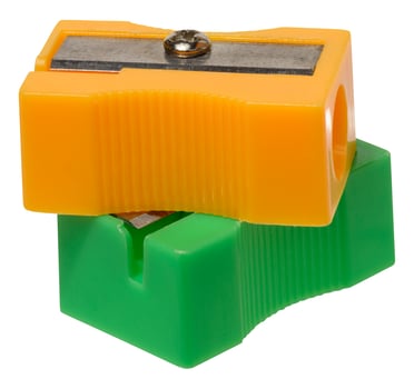 Orange and green plastic pencil sharpeners on isolated background photo