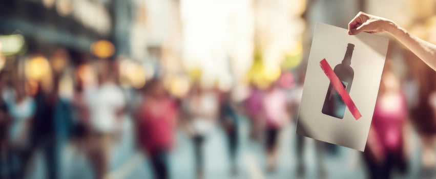 The hand holding a sign against alcohol during a lively street protest. photo