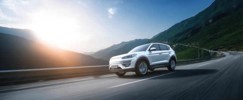 The sleek SUV cruising along a scenic mountain road at sunset. photo