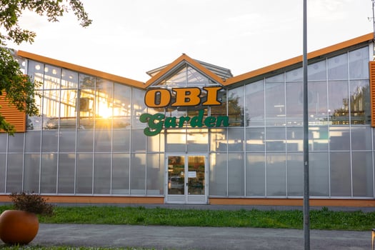 Piacenza, Italy - May 11, 2025 Warm sunset light reflecting off the expansive glass facade of a gardening store OBI, creating an inviting atmosphere for plant enthusiasts photo