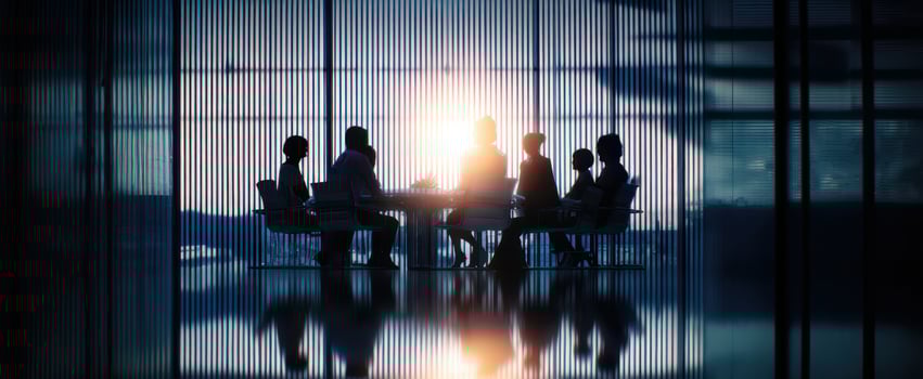 The silhouette of a diverse business team collaborating during sunset. photo