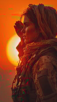 Military woman saluting at sunset with bright orange sky in the background photo