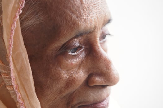 Elderly woman gazing thoughtfully near window light photo